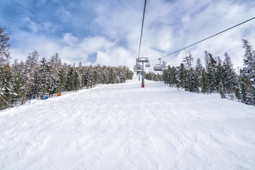 Fototapeta na wymiar Empty ski slope, winter landscape with ski lift