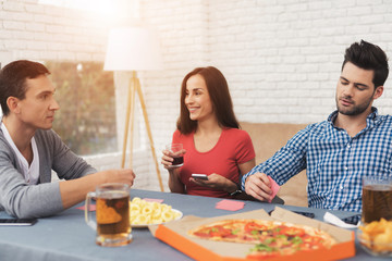 The company of young people plays cards.