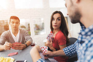 The company of young people plays cards.