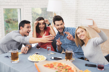 The company of young people play the game with stickers on the forehead.