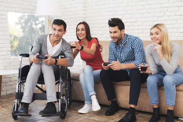 Fototapeta premium Two guys and two girls play on the game console.