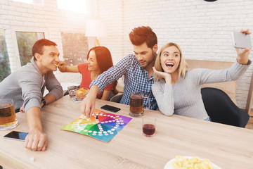 Young people play a board game using a dice and chips.