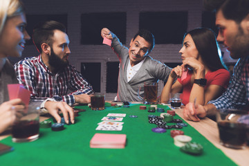 Young people play poker at the table.