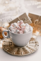 Cup of hot chocolate and marshmallow in the background of Christmas decorations.
