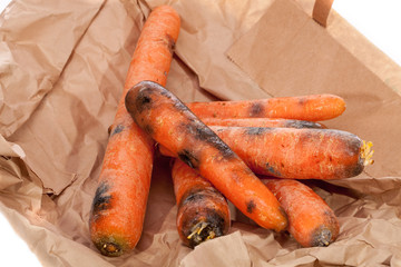 Rotten carrots. Wasted black and mouldy vegetables. Gone off food.