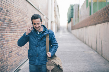 young man with backpack talking on the phone