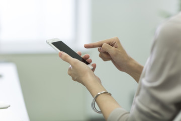 スマートフォンを操作するビジネスウーマン