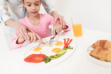 My mother served breakfast for her daughter. She teaches the child to eat right.