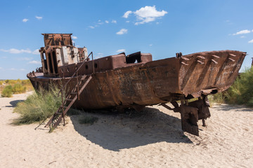 Fototapeta premium Rusted abandoned vessel in the ship cemetery of Aral Sea, Muynak, Uzbekistan