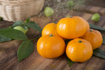 pile of whole fresh Tangerine or Mandarin orange on cutting board