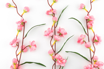Obraz na płótnie Canvas Fake pink flower branches on white background 