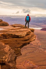 A hiker overlooking the valley and sunset in Canyonlands - 181865685