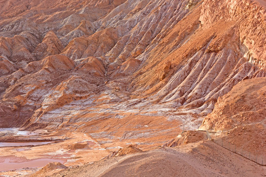 Red rocks with salt deposits in San Pedro de Atacama, Chile. Rock formation patterns left by volcanic activity of the past in the famous desert