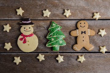 Festive Christmas Cookie and New Year in the shape of Christmas tree, Gingerbread man, snowman, Snowflake, star on wooden table