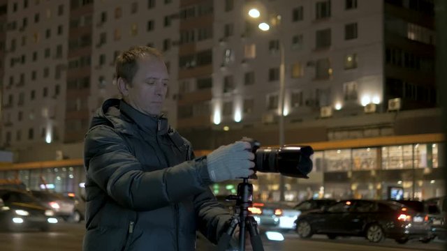 A person takes pictures of the night city.