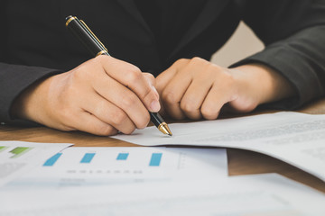 Close up businessman signing terms of agreement  documents on his desk, signing concept, signing concept