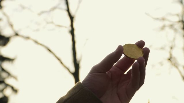 Man holds bitcoin against sky