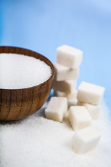 Fototapeta na wymiar Sugar in a bowl and cubes of sugar