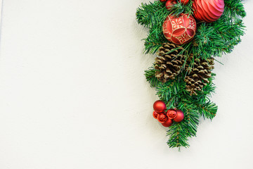 Close up of decorated Christmas tree, decoration fir cones and fir branches  on white wall background
