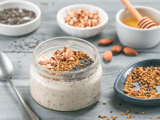 Overnight oats in jar and ingredients on gray wooden table