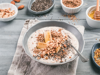 Overnight oats in bowl and ingredients on gray wooden table