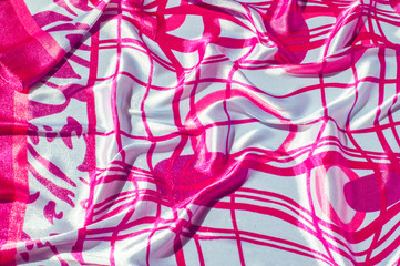 Texture, fabric, background. Texture of a female dress with an abstract red pattern on a white background. Silk fabric geometric shapes