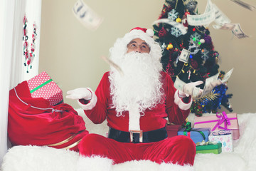 Santa claus holding money and looking at them.