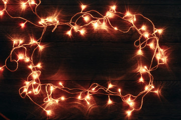 A frame of Christmas garlands on a wooden table. Holidays christmas background. Copy space for text or design. View from above.