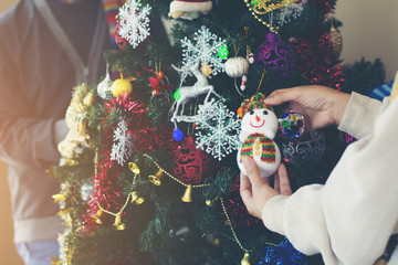 Portrait of happy family decorating Christmas tree.