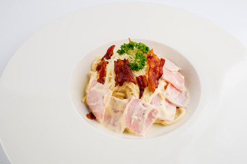 Spaghetti carbonara with cream on white plate isolated on white background