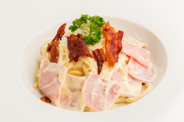 Spaghetti carbonara with cream on white plate isolated on white background