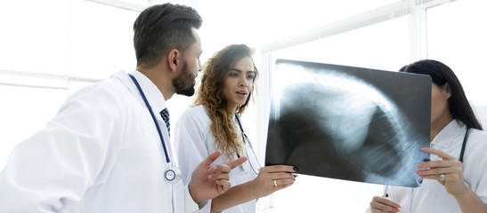 medical workers looking at patient's x-ray film