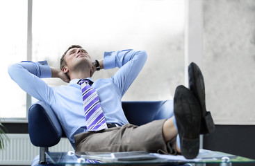 Young businessman leaning back in his chair