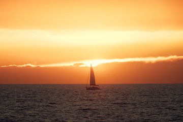 Beautiful sunset at the sea with sailing boat