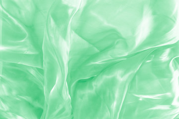 Background texture, pattern. Green silk background with some soft folds and highlights. green...