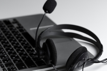 call center support concept. headset on keyboard computer laptop