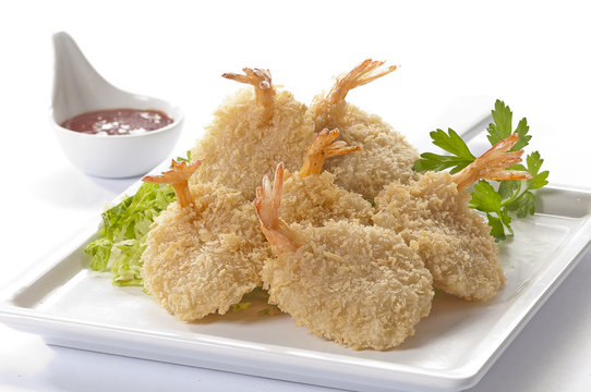 Breaded Butterfly Jumbo Shrimps with salad and salsa dip on white plate and white background 