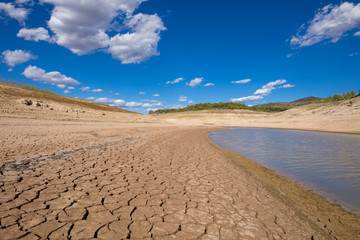 Fototapeta na wymiar landscape of low level water and dry earth ground in advance, extreme drought in Entrepenas reservoir, in Guadalajara, Castile, Spain, Europe 