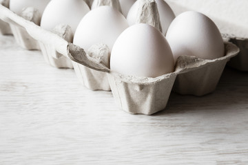 White eggs in the eggs box on the kitchen table. Food concept.