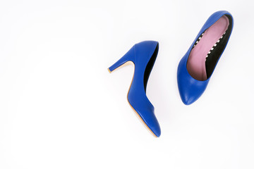 Female blue high-heeled shoes on white background, Flat lay, top view trendy fashion feminine background.
