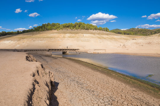 landscape of low level water and dry earth land with broken bridge, extreme drought in Entrepenas reservoir, in Guadalajara, Castile, Spain, Europe
