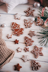 A variety of Christmas gingerbread cookies are laid out on a whi