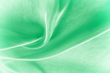 Background texture, pattern. Green silk background with some soft folds and highlights. green...