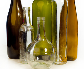 Background pattern and texture featuring empty bottles for studio photography. The bottles come in a variety of colors including green, clear, white, brown and blue. A group of bottles creates a visua