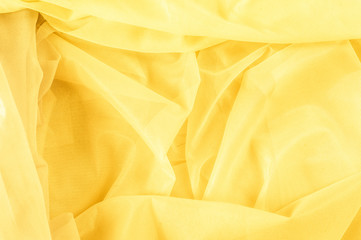 Texture, background, pattern. The texture of the silk fabric is yellow. Silk fabric is transparent.