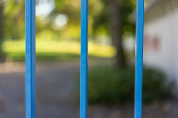 closed park seen through blue gate in summer