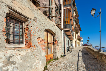 Old houses and narrow cobbled street in town of La Morra, Italy.