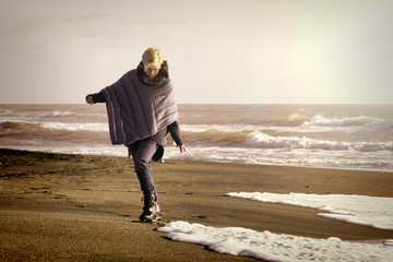 Woman that walks on the seashore in winter