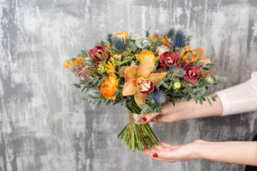 beautiful wedding bouquet of mixed flowers in woman hand. the work of the florist at a flower shop