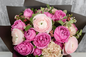 beautiful bouquet of mixed flowers into a vase on table. the work of the florist at a flower shop. Copy pace